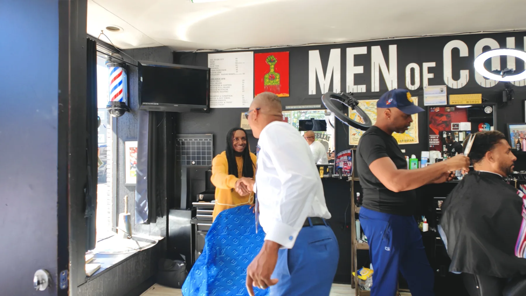 James Armstrong greeting a community member inside a local barbershop