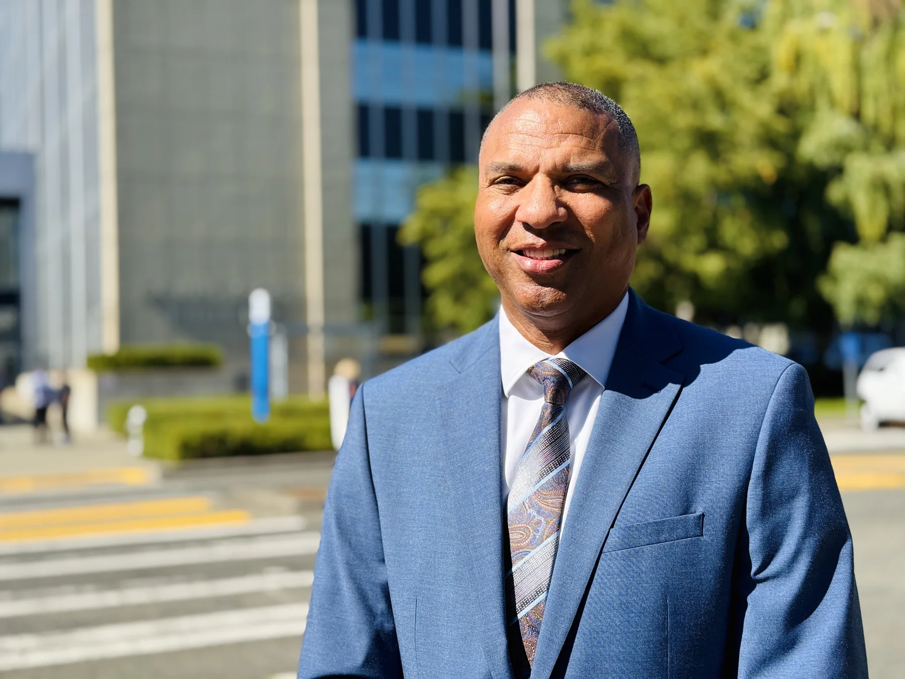 James Armstrong in a blue suit outside a civic building