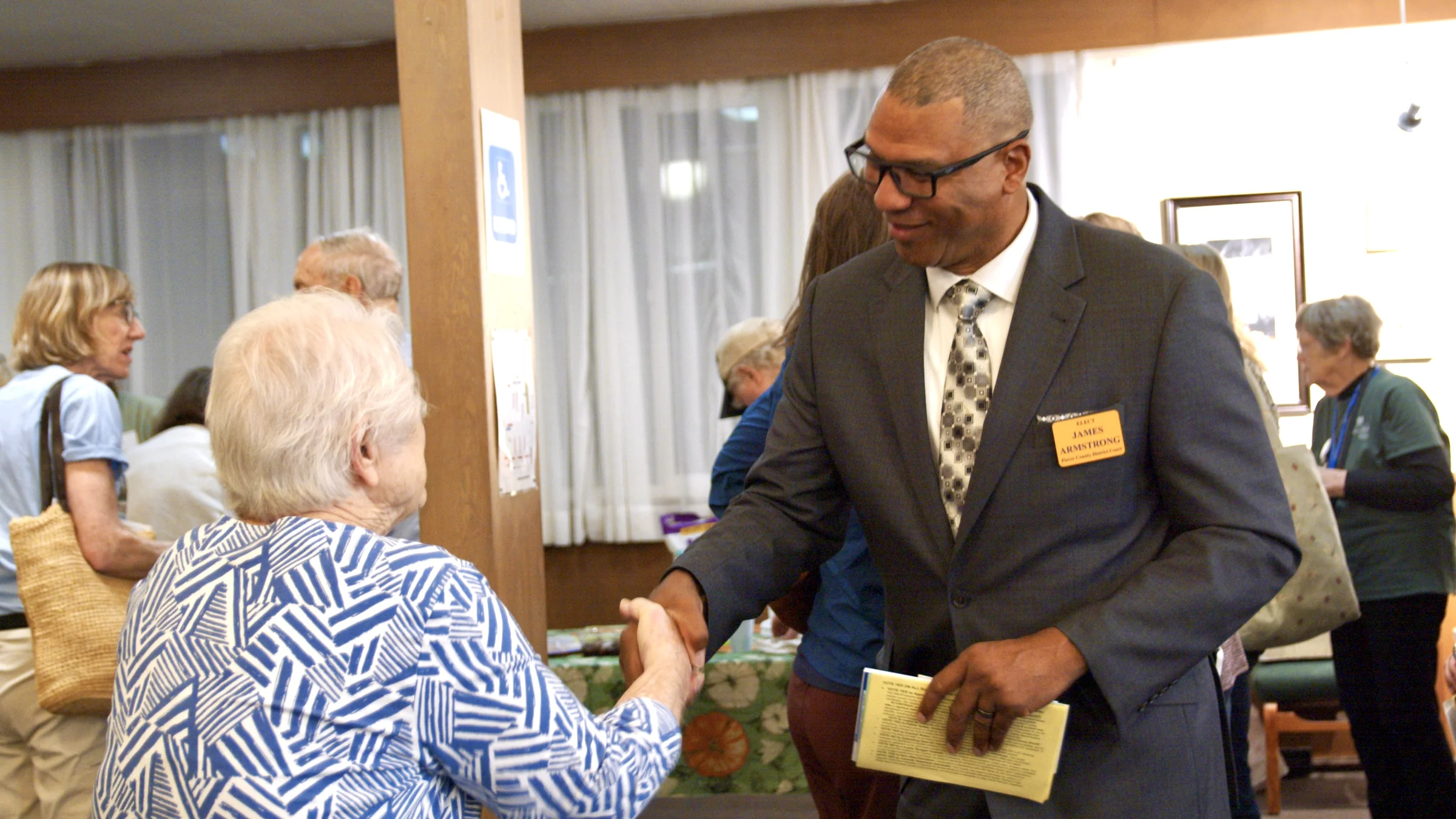 James Armstrong greeting a community member with a handshake
