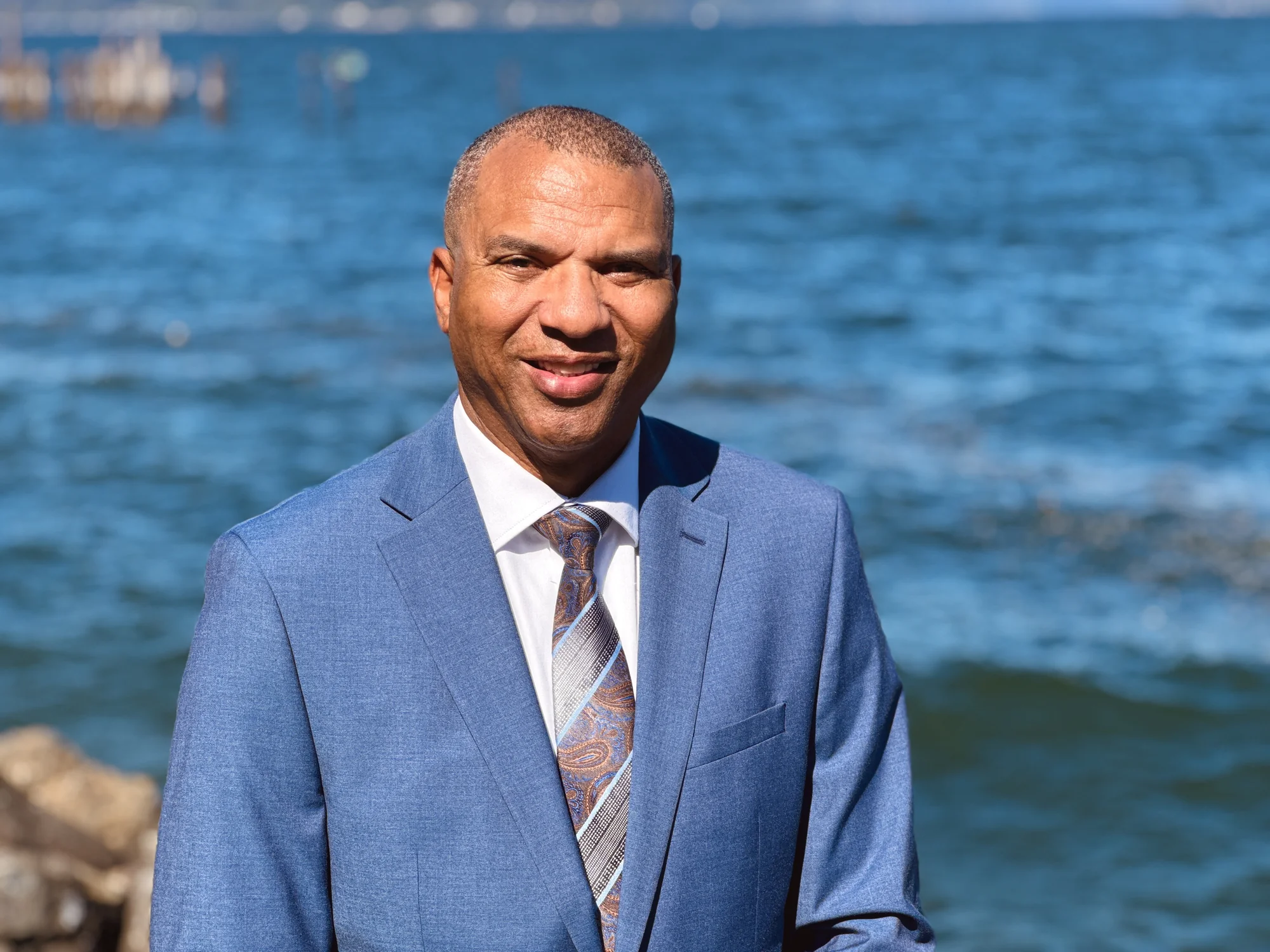 James Armstrong in a blue suit beside the waterfront